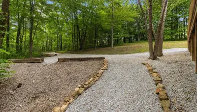 a path in the woods with a bench on it at Trails End Cabin- Sauna, Arcade, Hot Tub, Firepit in Logan