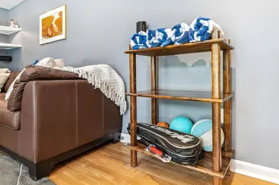 a shelf next to a couch with a suitcase at Spacious Family Getaway- Salt Water Pool & Hot Tub in Lyndhurst