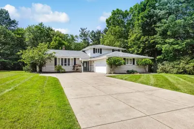 a white house with a driveway at Spacious Family Getaway- Salt Water Pool & Hot Tub in Lyndhurst