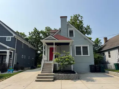 a blue house with a red door on a street at Spacious 3 bed 2 and a half bath 2pk spot in Cincinnati