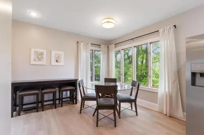 a dining room with a table and chairs and windows at Spacious 3 bed 2 and a half bath 2pk spot in Cincinnati