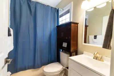 a bathroom with a toilet and a sink and a mirror at Spacious 3 bed 2 and a half bath 2pk spot in Cincinnati