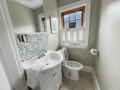 a white bathroom with a toilet and a sink at Spacious 3 bed 2 and a half bath 2pk spot in Cincinnati