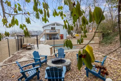 a yard with blue chairs and a fire pit at Green Destiny! 7min to DT Cincy, Pool & Hottub in Ludlow