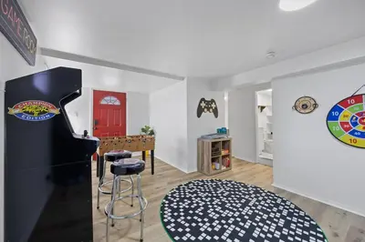 a living room with a piano and a red door at Green Destiny! 7min to DT Cincy, Pool & Hottub in Ludlow