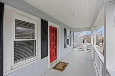 a porch with a red door and a window at Green Destiny! 7min to DT Cincy, Pool & Hottub in Ludlow