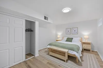 a white bedroom with a bed and a door at Green Destiny! 7min to DT Cincy, Pool & Hottub in Ludlow