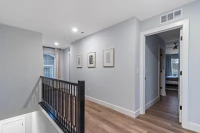 a hallway with white walls and a staircase with wood floors at Oakley Gold Std New Construc 4king bed 4ens bthrm in Cincinnati