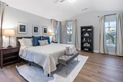 a bedroom with a large bed with blue pillows at Oakley Gold Std New Construc 4king bed 4ens bthrm in Cincinnati