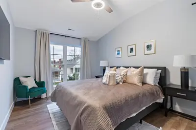 a bedroom with a large bed and a green chair at Oakley Gold Std New Construc 4king bed 4ens bthrm in Cincinnati
