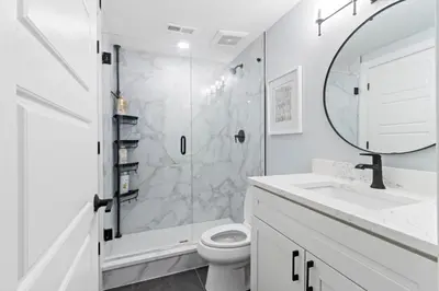 a bathroom with a shower and a toilet and a sink at Oakley Gold Std New Construc 4king bed 4ens bthrm in Cincinnati