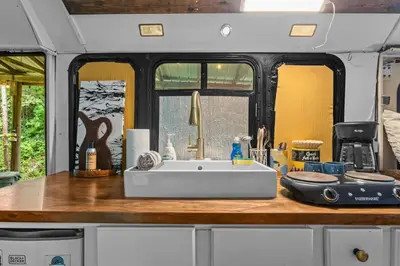 a kitchen with a white sink in an rv at Covered Bridge Tiny Home Bus On The Water In Rrg in Stanton