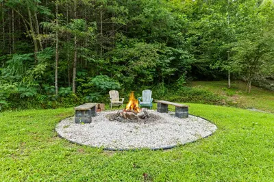 a fire pit in the middle of a yard at Covered Bridge Tiny Home Bus On The Water In Rrg in Stanton