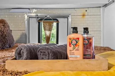 a wooden tray with two bottles of soap and towels at Covered Bridge Tiny Home Bus On The Water In Rrg in Stanton