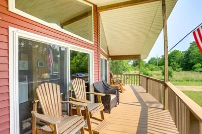 a porch with rocking chairs on a house at Walk to Lake Kelleys Island Gem with Deck! in Kelleys Island