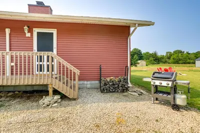 a house with a bbq and a grill in front of it at Walk to Lake Kelleys Island Gem with Deck! in Kelleys Island