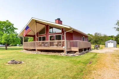 a large red house with an american flag on it at Walk to Lake Kelleys Island Gem with Deck! in Kelleys Island