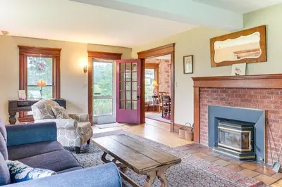 a living room with a couch and a fireplace at 2 Mi to Chardon Square Spacious Farmhouse in Concord