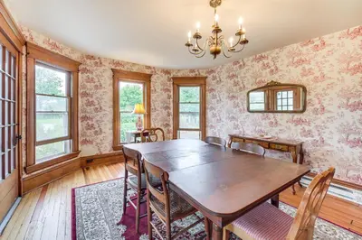 a dining room with a wooden table and chairs at 2 Mi to Chardon Square Spacious Farmhouse in Concord