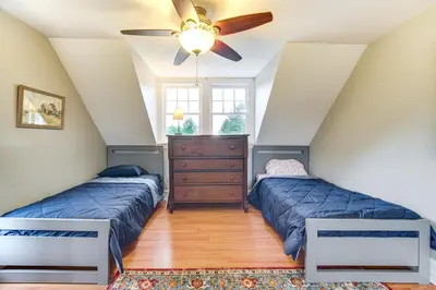 two beds in a room with a ceiling fan at 2 Mi to Chardon Square Spacious Farmhouse in Concord