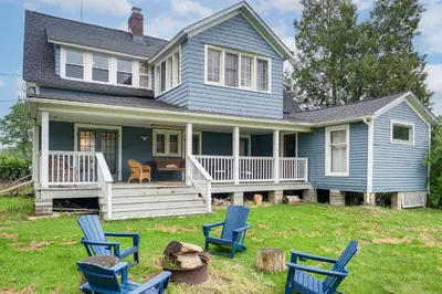 a blue house with blue chairs in the yard at 2 Mi to Chardon Square Spacious Farmhouse in Concord