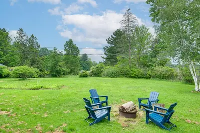 two blue chairs sitting in a yard at 2 Mi to Chardon Square Spacious Farmhouse in Concord
