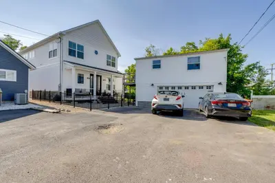 two cars parked in front of a white house at Steps to Buckeye Lake Family-Friendly Home in Buckeye Lake
