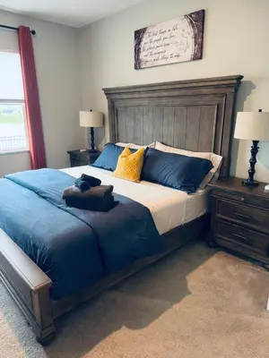 a bedroom with a large bed with a wooden headboard at Modern, newer home, King bed, near Indianapolis in Pendleton