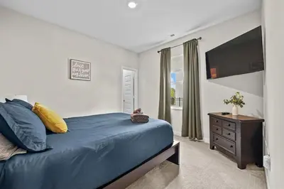 a bedroom with a blue bed and a television at Modern, newer home, King bed, near Indianapolis in Pendleton