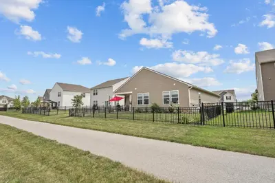 a house with a fence in front of a yard at Modern, newer home, King bed, near Indianapolis in Pendleton