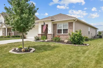 a house with an american flag in the yard at Modern, newer home, King bed, near Indianapolis in Pendleton