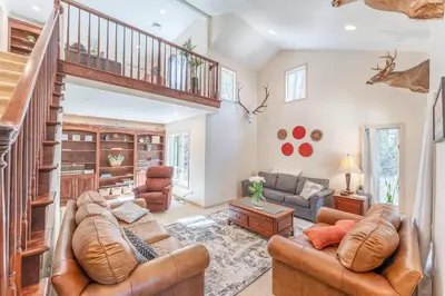 a living room with leather furniture and a staircase at Spring Mountain Cove in Warsaw