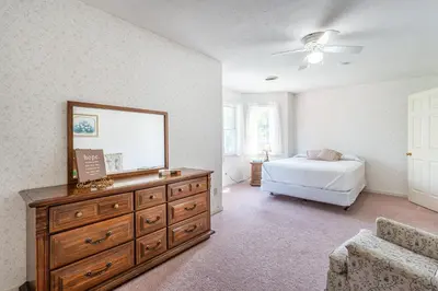 a bedroom with a dresser with a mirror and a bed at Country Cottage in Apple Creek