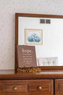 a sign on top of a dresser with a mirror at Country Cottage in Apple Creek