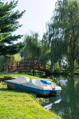 a boat parked on the side of a river with a bridge at Country Cottage in Apple Creek