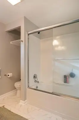 a glass shower in a bathroom with a toilet at White Oak Cottage in Mount Orab