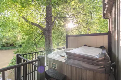 a hot tub on a balcony with a tree at White Oak Cottage in Mount Orab