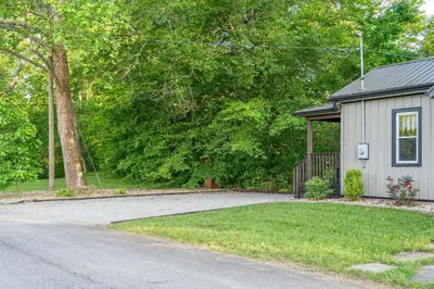 a house with a driveway next to a building at White Oak Cottage in Mount Orab
