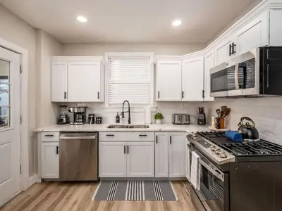 a kitchen with white cabinets and stainless steel appliances at Oakwood Charm Family-Friendly 3BR Getaway in Columbus