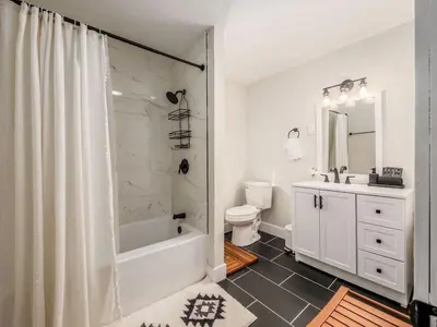 a bathroom with a tub and a toilet and a sink at Oakwood Charm Family-Friendly 3BR Getaway in Columbus