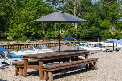 a picnic table with an umbrella next to boats at Floating Tiny Home #1 in Vermilion
