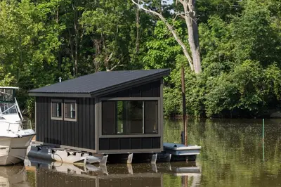 a small cabin on a boat in the water at Floating Tiny Home #1 in Vermilion