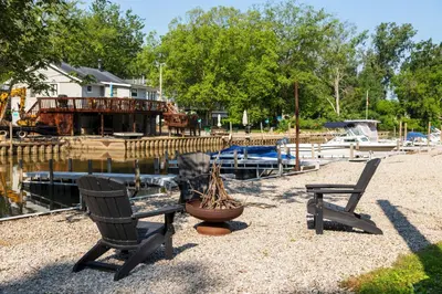 two chairs sitting on the gravel near a marina at Floating Tiny Home #1 in Vermilion
