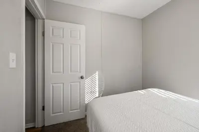 a white bedroom with a bed and a white door at The Cozy Bellows - Retreat for 4 in Columbus