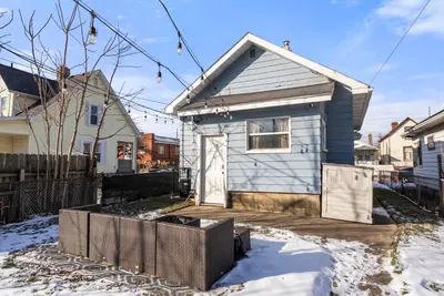 a small blue house in a yard with snow at The Cozy Bellows - Retreat for 4 in Columbus