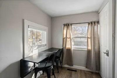 a dining room with a table and two windows at The Cozy Bellows - Retreat for 4 in Columbus