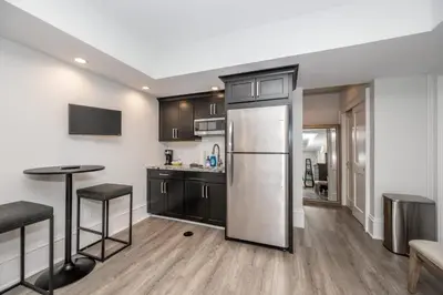 a kitchen with a stainless steel refrigerator and a table at Mt Adams Nest - Studio for 2 in Cincinnati