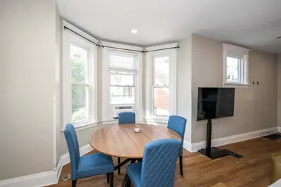 a dining room with a wooden table and blue chairs at Ludlow Lodge with City Views in Ludlow