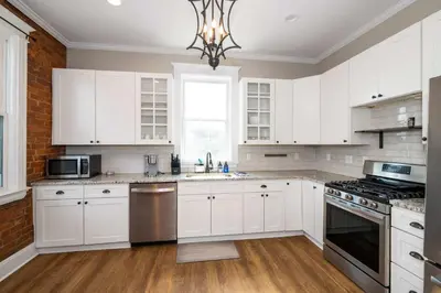 a kitchen with white cabinets and a chandelier at Ludlow Lodge with City Views in Ludlow