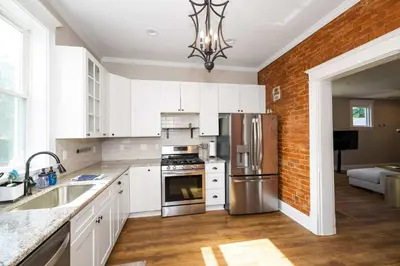 a kitchen with white cabinets and stainless steel appliances at Ludlow Lodge with City Views in Ludlow